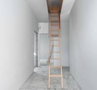 I NA PREDAJ 4i rodinný dom s veľkým pozemkom v Galante - Biely interiér s dreveným rebríkom vedúcim do podkrovia v rodinnom dome.