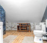 I Predaj štýlového tehlového domu v Rajke pri Bratislave - Kúpeľňa v rodinnom dome s podlahou s dreveným dekorom a mramorovými obkladmi.