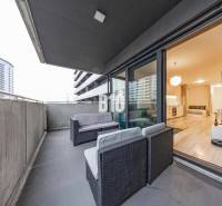 TEHELNÉ POLE | 1-izbový byt s priestrannou terasou - Balkón s výhľadom a priestranný interiér 1-izbového bytu s podlahou s dreveným dekorom.