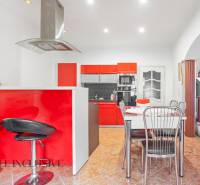 NA PREDAJ RODINNÉ DOMY S GARÁŽOU, DUNAJSKÁ STREDA - Kuchyňa v rodinnom dome s červenými skrinkami, jedálenským stolom a schodiskom.