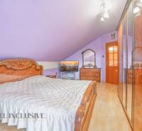 NA PREDAJ RODINNÉ DOMY S GARÁŽOU, DUNAJSKÁ STREDA - Podkrovná spálňa s dreveným nábytkom a fialovými stenami v rodinnom dome.