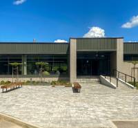 Zariadený 3-izb. byt, Stará Ľubovňa, Mierová ul. - Na ulici Tatranská vidno budovu so záhradou, lavičkami a prístupovou cestou.