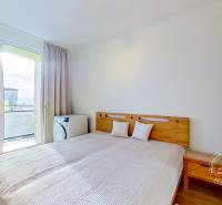 Zariadený 3-izb. byt, Stará Ľubovňa, Mierová ul. - Spálňa v 3-izbovom byte s posteľou a výhľadom cez balkónové dvere.