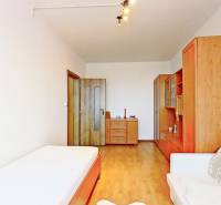 Zariadený 3-izb. byt, Stará Ľubovňa, Mierová ul. - Izba v 3-izbovom byte s podlahou s dreveným dekorom a jednoduchým nábytkom.