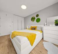ROVINKA-Prenájom modernej, zariadenej novostavby 4 izbového rod.domu - Svetlá spálňa s posteľou, bielym nábytkom, rastlinami a podlahou s dreveným dekorom v 4-izbovom byte.