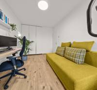 ROVINKA-Prenájom modernej, zariadenej novostavby 4 izbového rod.domu - Izba v 4-izbovom byte so zeleným gaučom, počítačom a podlahou s dreveným dekorom.