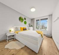 ROVINKA-Prenájom modernej, zariadenej novostavby 4 izbového rod.domu - Spálňa s posteľou a dekoráciami na stene, podlaha s dreveným dekorom.