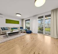 ROVINKA-Prenájom modernej, zariadenej novostavby 4 izbového rod.domu - Obývacia izba so sedačkou, presklenými dverami a podlahou s dreveným dekorom v 4-izbovom byte.