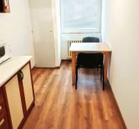 3 izbový byt pri električkovej trati s výhľadom na Draždiak - Kuchyňa v 3-izbovom byte s podlahou s dreveným dekorom a stolom pre dve osoby.