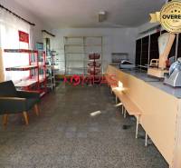 INVESTIČNÁ PRÍLEŽITOSŤ, BUDOVA NA PODNIKATEĽSKÉ ÚČELY - KALINKA - Interiér obchodných priestorov s pultom, regálmi a kreslom.