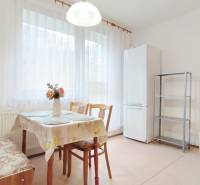 | 2-izbový byt 68m2, Štvrť SNP | Trenčianske Teplice  - Kuchyňa v 2-izbovom byte s jedálenským stolom, stoličkami a chladničkou.