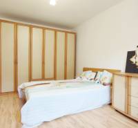 | 2-izbový byt 68m2, Štvrť SNP | Trenčianske Teplice  - Spálňa s poschodovou posteľou, šatníkom, komodou a podlahou s dreveným dekorom v 2-izbovom byte.