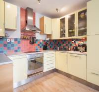 Pozrite si PRÍJEMNÝ 2i byt so ZARIADENÍM, LODŽIOU a KLIMATIZÁCIOU - Kuchyňa v 2-izbovom byte s farebným obkladom a podlahou s dreveným dekorom.