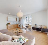 Krásny moderne zariadený 3-izb. byt I novostavba I Stupava - Obývačka s kuchynským kútom v 3-izbovom byte, svetlá podlaha s dreveným dekorom.