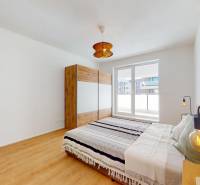 Krásny moderne zariadený 3-izb. byt I novostavba I Stupava - Svetlá spálňa s pohodlnou posteľou, vstavanou skriňou a podlahou s dreveným dekorom.