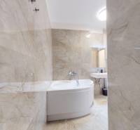 | Exkluzívny 4-izbový byt s obrovskou terasou | Stupava - Kúpeľňa v 4-izbovom byte s vaňou a svetlými obkladmi.