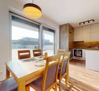 | Exkluzívny 4-izbový byt s obrovskou terasou | Stupava - Jedáleň a kuchyňa v 4-izbovom byte s podlahou s dreveným dekorom.