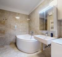 | Exkluzívny 4-izbový byt s obrovskou terasou | Stupava - Kúpeľňa s vaňou v 4-izbovom byte, kamenné obklady a biela sanita.