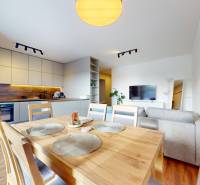 | Exkluzívny 4-izbový byt s obrovskou terasou | Stupava - Jasná kuchyňa s jedálňou a pohovkou v 4-izbovom byte, podlaha s dreveným dekorom.