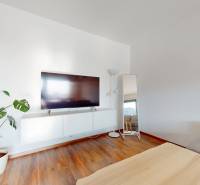 | Exkluzívny 4-izbový byt s obrovskou terasou | Stupava - Obývačka 4-izbového bytu s televízorom, kvetinou a podlahou s dreveným dekorom.