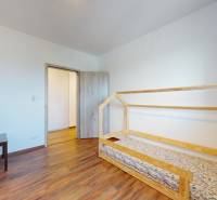 | Exkluzívny 4-izbový byt s obrovskou terasou | Stupava - Detská izba so svetlými stenami, dreveným dekorom podlahy a jednoduchým nábytkom v 4-izbovom byte.
