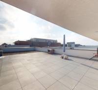 | Exkluzívny 4-izbový byt s obrovskou terasou | Stupava - Priestranná terasa 4-izbového bytu na Cementárenskej ulici v Stupave s výhľadom na okolité budovy.