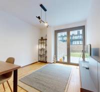 METROPOLIS I Nový Luxusný 2i byt s predzáhradkou I - Obývacia izba s podlahou s dreveným dekorom v 2-izbovom byte a priestranným oknom na terasu.