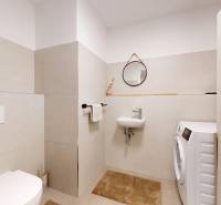 METROPOLIS I Nový Luxusný 2i byt s predzáhradkou I - Kúpeľňa v 2-izbovom byte, béžové obklady, práčka, zrkadlo a umývadlo.