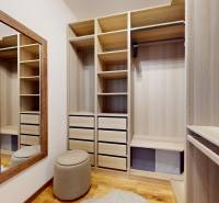 METROPOLIS I Nový Luxusný 2i byt s predzáhradkou I - Šatníková skriňa s policami a zrkadlom v 2-izbovom byte, podlaha s dreveným dekorom.