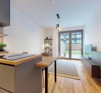 METROPOLIS I Nový Luxusný 2i byt s predzáhradkou I - Kuchyňa s podlahou s dreveným dekorom v 2-izbovom byte, vedie do slnečnej obývačky.