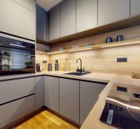 METROPOLIS I Nový Luxusný 2i byt s predzáhradkou I - Kuchyňa s dreveným dekorom a modernými spotrebičmi v 2-izbovom byte.