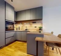 METROPOLIS I Nový Luxusný 2i byt s predzáhradkou I - Kuchyňa v 2-izbovom byte s podlahou s dreveným dekorom a sivými skrinkami.
