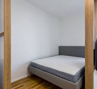 REZERVOVANÉ I METROPOLIS I Luxusný 1i byt I Staré Mesto - Manželská posteľ v 1-izbovom byte, podlaha s dreveným dekorom, svetlé steny.