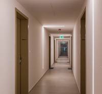 REZERVOVANÉ I METROPOLIS I Luxusný 1i byt I Staré Mesto - Koridor budovy s rovnými stenami, dverami a osvetlením, pripomínajúci hotelový interiér.