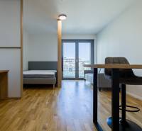 REZERVOVANÉ I METROPOLIS I Luxusný 1i byt I Staré Mesto - Interiér 1-izbového bytu s podlahou s dreveným dekorom, posteľou a pracovným stolom.