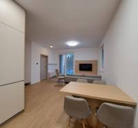 Prenájom: Lukratívny 2-izbový byt v Poprade na Novom nábreží - Obývacia izba v 2-izbovom byte s podlahou s dreveným dekorom a otvorenou kuchyňou.