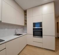 Prenájom: Lukratívny 2-izbový byt v Poprade na Novom nábreží - Kuchyňa v 2-izbovom byte s podlahou s dreveným dekorom, svetlými skrinkami a vstavanou rúrou.