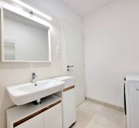 Pekný a moderný 3-izbový byt I Arboria Trnava - Kúpeľňa v 3-izbovom byte s umývadlom a práčkou, svetlé obklady na stenách.