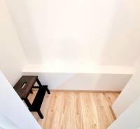 Pekný a moderný 3-izbový byt I Arboria Trnava - Malý biely priestor s dreveným dekorom a tmavým stolíkom v 3-izbovom byte.