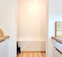 Pekný a moderný 3-izbový byt I Arboria Trnava - Kuchyňa v 3-izbovom byte s podlahou s dreveným dekorom a svetlými stenami.