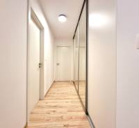 Pekný a moderný 3-izbový byt I Arboria Trnava - Chodba v 3-izbovom byte so vstavanou skriňou a podlahou s dreveným dekorom.