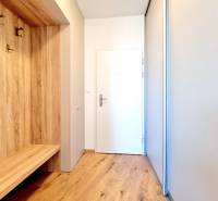 Posledný investičný krásny 2-izbový byt | 55 m² | RÍNOK RAČA - Chodba 2-izbového bytu s podlahou s dreveným dekorom a bielymi stenami.