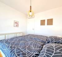 Posledný investičný krásny 2-izbový byt | 55 m² | RÍNOK RAČA - Svetlá spálňa v 2-izbovom byte s dekorom, posteľou a bielym nábytkom.