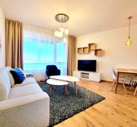 Posledný investičný krásny 2-izbový byt | 55 m² | RÍNOK RAČA - Obývačka v 2-izbovom byte s podlahou s dreveným dekorom, sedačkou a jedálenským stolom.