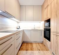 Posledný investičný krásny 2-izbový byt | 62 m² | RÍNOK RAČA - Svetlá kuchyňa s podlahou s dreveným dekorom a vstavanými spotrebičmi v 2-izbovom byte.