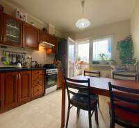 | PREDAJ | 3i byt s krásnym výhľadom vo vyhľadávanej časti BA - Kuchyňa v 3-izbovom byte s drevenými skrinkami, jedálenským stolom a oknom na balkón.