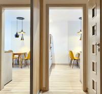 Moderný unikát - 1,5- izb. byt s 2 loggiami na prenájom (Nad jazerom) - Osvetlená jedáleň s kuchynským stolom a žltými stoličkami v 1-izbovom byte.