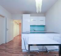 Predaj útulný 2 izbový byt, novostavba, super lokalita Jégeho ulica. - Kuchyňa 2-izbového bytu s bielymi skrinkami, modrou backsplash a podlahou s dreveným dekorom.