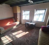 Ponúkame na predaj záhradný domček - Jasová - Izba v rodinnom dome s pohovkami, stolíkom a kobercom, zdroj Jasová.