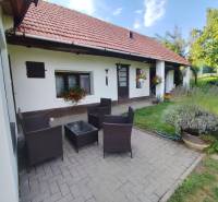 Ponúkame na predaj záhradný domček - Jasová - Rodinný dom v Jasovej s terasou, ratanovým nábytkom a upravenou záhradou.